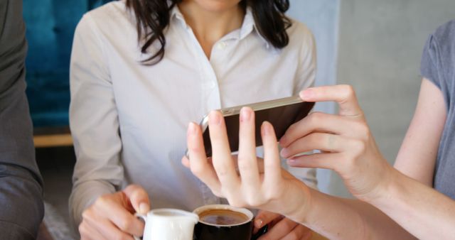 Businesswomen Discussing Work Over Coffee on Smartphone - Download Free Stock Images Pikwizard.com