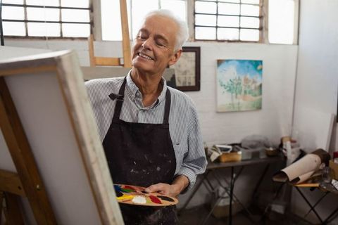 Senior artist enjoying creative painting session in art studio