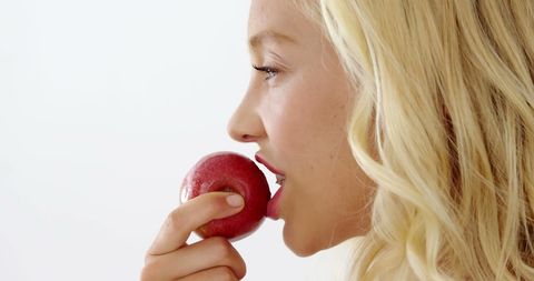 Woman about to bite fresh red apple for healthy lifestyle