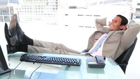 Successful Businessman Relaxing at Office Desk with Cityscape View