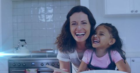 Joyful mother-daughter baking moment in kitchen