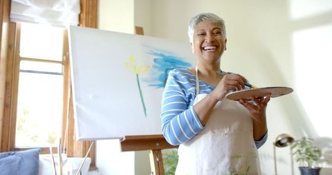 Senior Woman Joyfully Painting at Home Studio