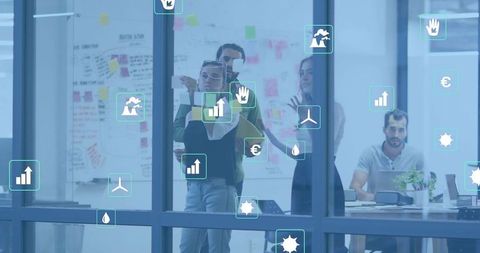 Team collaborating on strategy with sticky notes, charts and sustainability icons on office glass