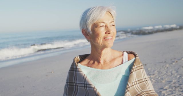 Elderly Woman Relishing Sea Breeze On Beach Wrapping in Plaid Blanket - Download Free Stock Images Pikwizard.com
