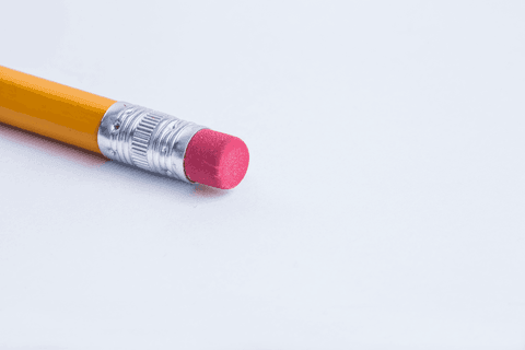 Transparent yellow pencil with red eraser on plain white background