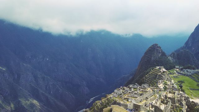 A breathtaking view of Machu Picchu, featuring ancient Incan ruins amid misty mountains in Peru. Perfect for travel brochures, historical education materials, and cultural tourism promotions, showing the grandeur and intrigue of this historical site elevated in the Andes range.