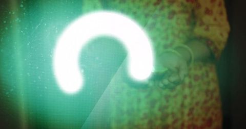 Woman holding glowing green arc projection over pixelated screen wearing floral dress and bangles