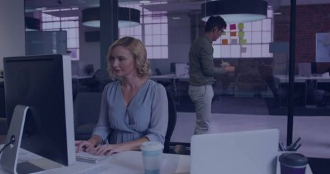 Modern Office Setting with Woman Typing at Workstation