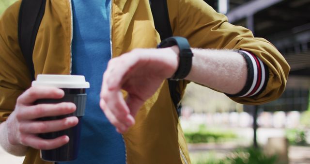 Man Holding Coffee Cup and Checking Smartwatch Outdoors - Download Free Stock Images Pikwizard.com