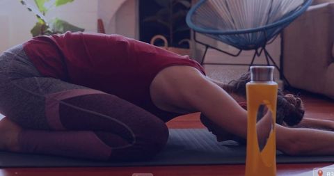 Middle aged woman practicing child's pose for wellness and relaxation