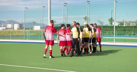 Male Field Hockey Teams Shaking Hands on Outdoor Synthetic Turf