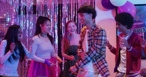 Teen Friends Dancing at Neon Disco Birthday Party with Disco Ball Glowsticks and Tinsel