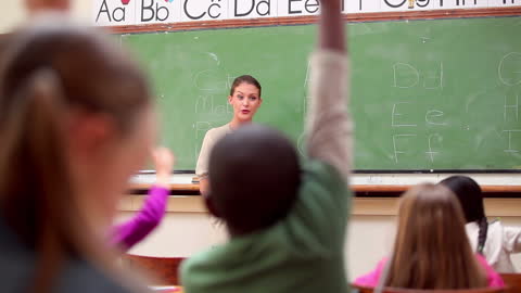 Teacher Engaging with Enthusiastic Classroom Students