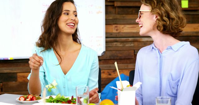 Two Young Women Enjoying Healthy Lunch Together in Office Setting - Download Free Stock Images Pikwizard.com