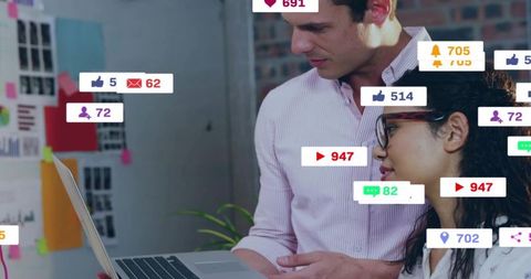 Reviewing social media metrics on laptop in creative office with notification overlays
