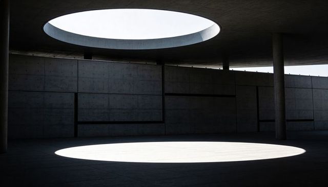 Oculus Revealing Elliptical Light on Brutalist Concrete Pavilion with Minimalist Geometry