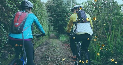 Two cyclists escaping into nature on forest path