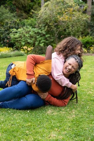 Joyful African American Family Playing on Grassy Lawn
