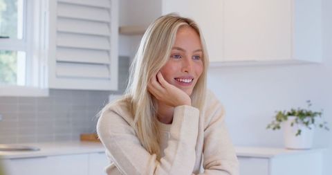 Smiling Woman Relaxing in Bright Modern Kitchen Environment