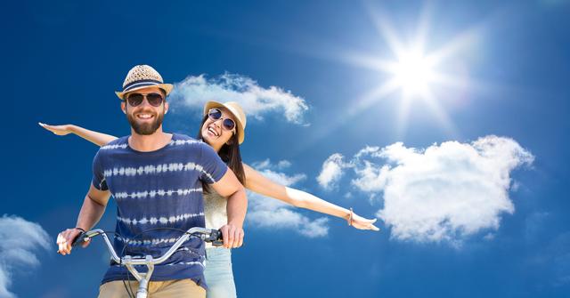 Digital composite of Happy couple riding bicycle against sky on sunny day