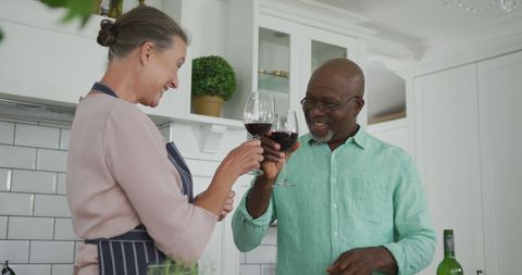 Senior Interracial Couple Enjoying Wine in Home Kitchen