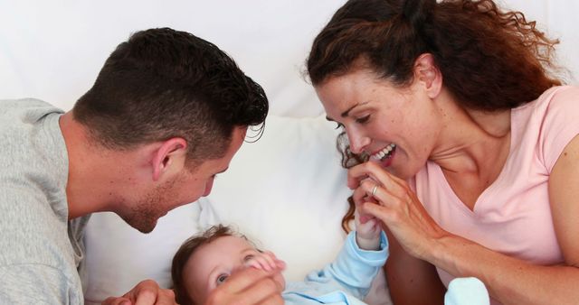 Happy Parents Playing with Baby on Bed - Download Free Stock Images Pikwizard.com