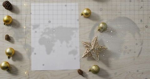 Dotted world map flatlay with gold baubles and glitter star for holiday travel planning