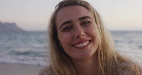 Smiling Woman Enjoying Serene Sunset Beach Moment