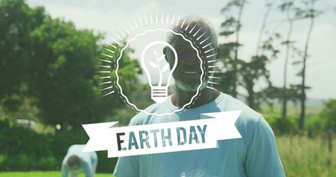 Smiling volunteer celebrating earth day cleanup in green park with eco lightbulb graphic