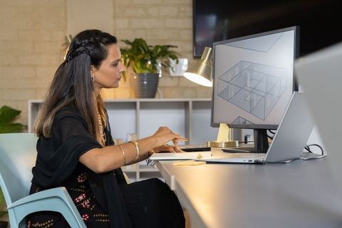 Indian architect designing 3d floor plan on monitor in contemporary studio workspace
