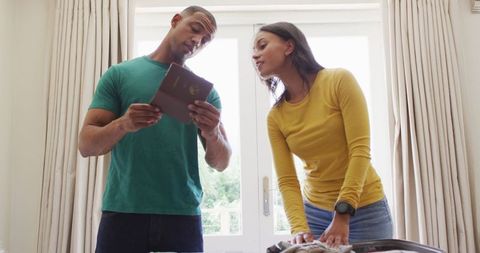 Couple Happily Preparing for Vacation, Looking at Travel Documents
