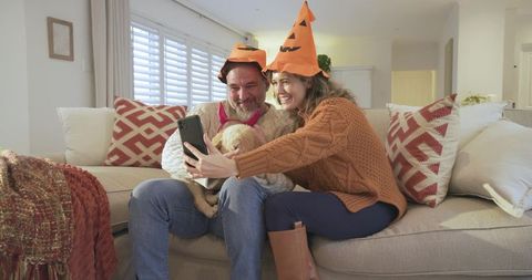 Couple Celebrating Halloween with Dog in Cozy Living Room