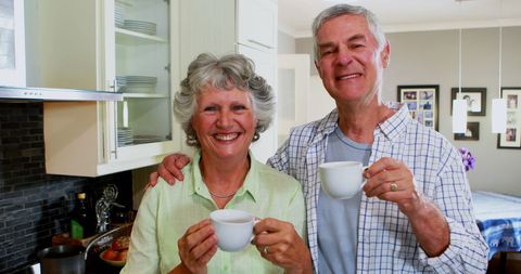 Happy Senior Couple Enjoying Tea in Cozy Kitchen