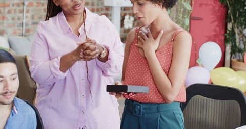 Office Colleagues Exchanging Gift Box During Festive Moment