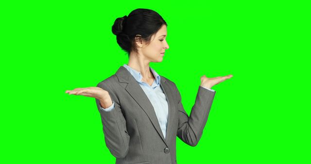 Businesswoman in Gray Suit Weighing Options Against Green Background - Download Free Stock Images Pikwizard.com