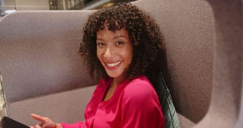 Smiling businesswoman relaxing in modern office lounge