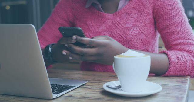 Person in Pink Sweater Using Smartphone and Laptop in Cafe - Download Free Stock Images Pikwizard.com