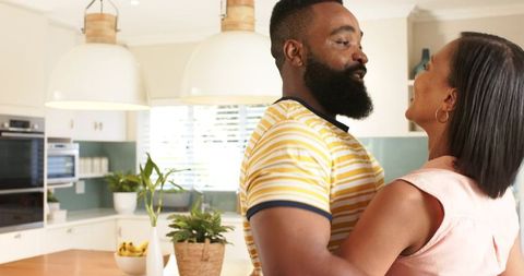 Couple Embracing in Modern Kitchen with Warm Lighting
