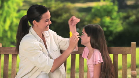 Mother and Daughter Enjoying Sunny Day with Flowers