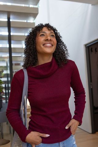 Smiling Woman Holding Tote Bag in Stylish Modern Foyer