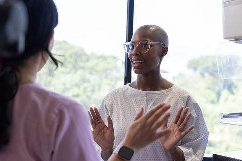 Female patient and clinician discussing medical imaging exam in bright clinic near window