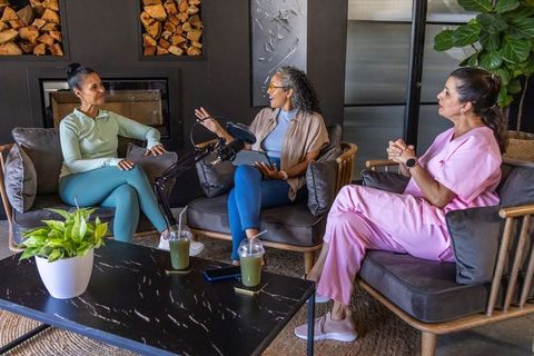 Recording women wellness podcast in modern lounge with microphones, tablets, green drinks