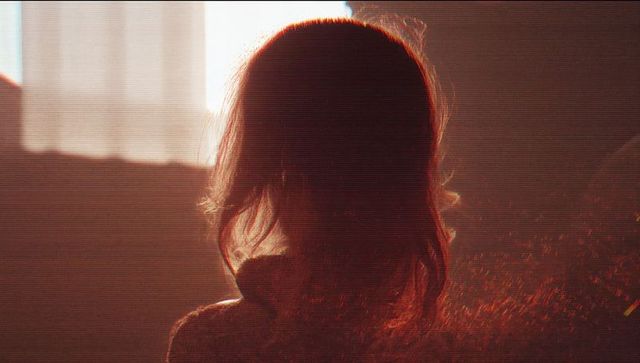 Silhouetted Woman Contemplating by Sunlit Window