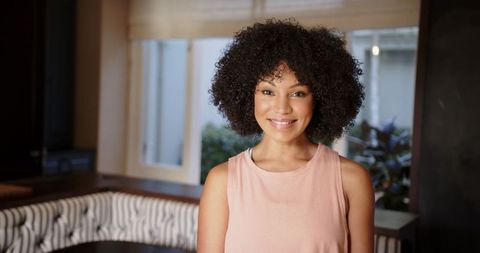 Confident woman smiling indoors in casual attire