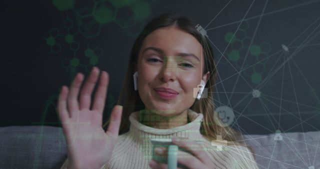 This image shows a woman waving at the camera during a virtual meeting, featuring digital interface overlays for a technological and futuristic look. She is smiling and wearing casual clothing, adding a personal touch to the atmosphere. Ideal for use in articles and advertisements about remote work, telecommunication, advancements in technology, or any content related to digital connectivity and virtual communication.