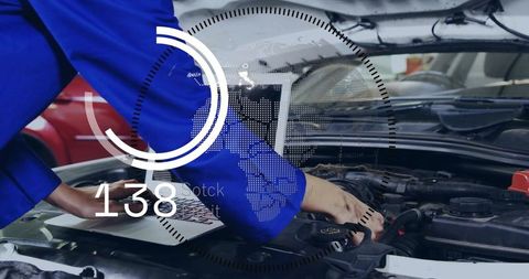 Female mechanic leaning over engine using laptop with digital diagnostics HUD overlay