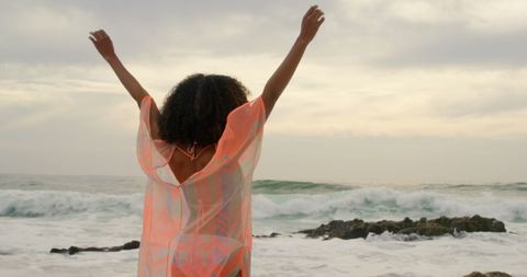 Joyful Woman in Flowing Dress Celebrating Beach Breeze
