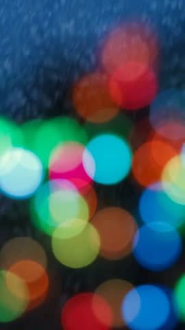 Vertical abstract bokeh lights glowing in dark frame for festive ambient background loop