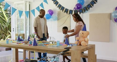 Family preparing birthday party decorations at home together