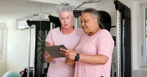 Senior Women Engaging in Gym Exercise with Tablet Technology
